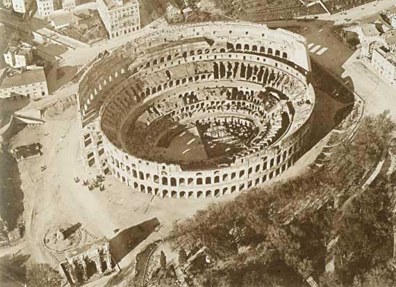 Aerial view of the valley of the Amphitheatre with the base of the Colossus of Nero, the Meta Sudans and the Arch of Constantine in a picture from about 1895.
